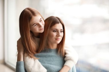 Mutlu anne ve kızı pencere yakınındaki portresi