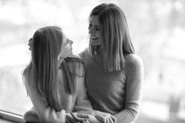 Mutlu anne ve kızı pencere yakınındaki siyah beyaz portre