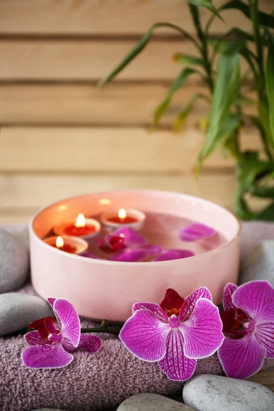 美丽的水疗组合兰花和漂浮的蜡烛在碗里 — 图库照片