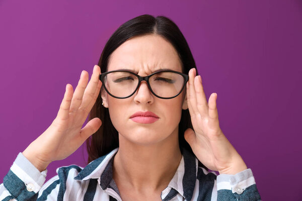 Portrait of woman with bad sight on color background