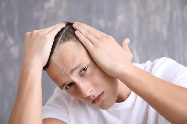 Man with hair loss problem on grey background