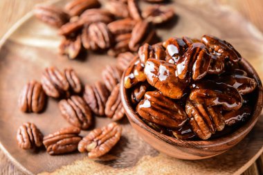 Ahşap plaka üzerinde lezzetli şekerlenmiş cevizli fındıklı kase