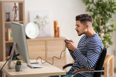 Genç adam bilgisayar oyunu evde oynamak