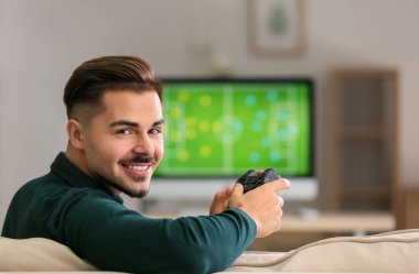 Genç adam evde video oyunu oynuyor.