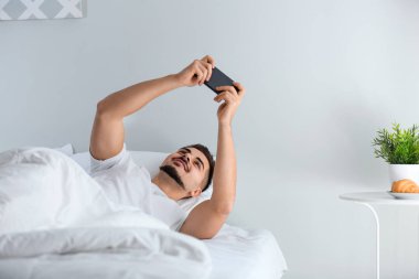 Genç adam akıllı yatakta oyun oynama