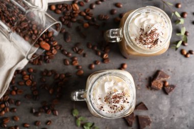 Mason jars of tasty coffee drink on grey table
