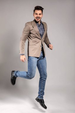 Yakışıklı adam gri arka plan üzerinde atlama