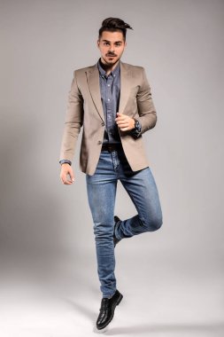 Yakışıklı adam gri arka plan üzerinde atlama