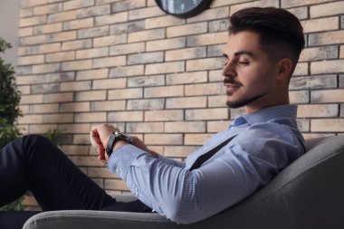 Onun koltukta otururken bakarak şık yakışıklı adam