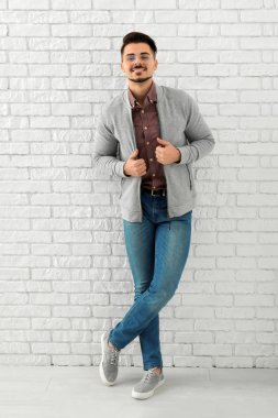 Şık yakışıklı adamın yanında beyaz tuğla duvar