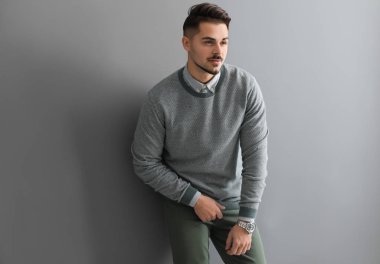 Gri arka plan üzerinde şık yakışıklı adam