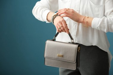 Güzel genç kadın şık Mücevherat ve renk arka plan üzerinde çanta