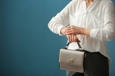 Güzel genç kadın şık Mücevherat ve renk arka plan üzerinde çanta