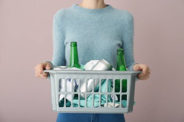 Renk arka plan üzerinde çöp kutusuyla tutan kadın. Geri dönüşüm kavramı