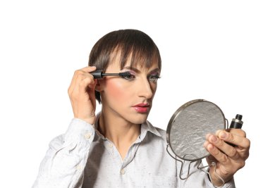 Portrait of transgender man applying makeup onto his face against white background clipart