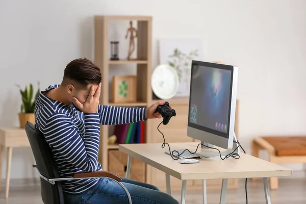 Bilgisayar oyunu evde kaybettikten sonra kızgın genç adam