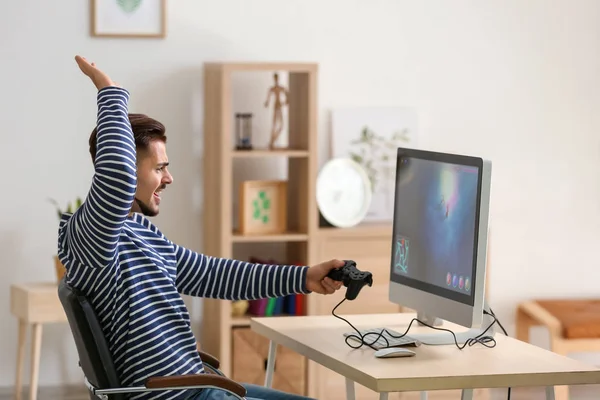 Bilgisayar oyunu evde kaybettikten sonra memnun genç adam