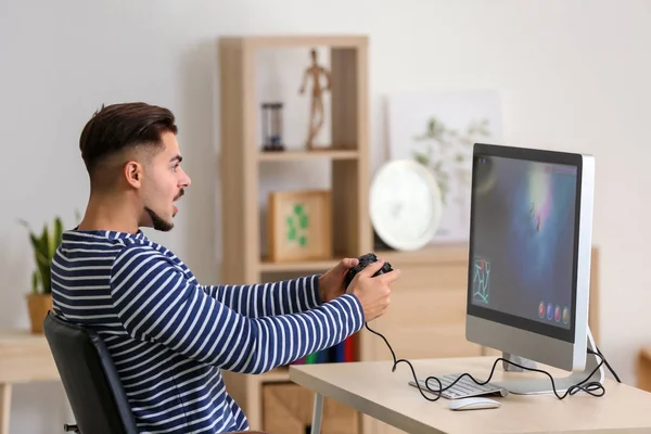 Genç adam bilgisayar oyunu evde oynamak