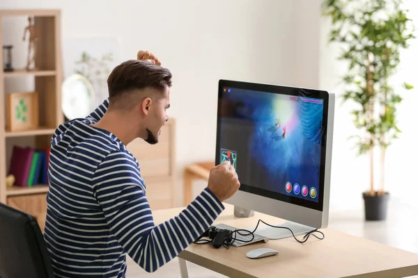 Bilgisayar oyunu evde kaybettikten sonra memnun genç adam