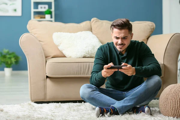 Νεαρός Άνδρας Που Παίζει Παιχνίδι Στο Smartphone Στο Σπίτι — Φωτογραφία Αρχείου