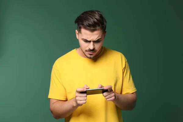 Young Man Playing Game Smartphone Color Background — Stock Photo, Image