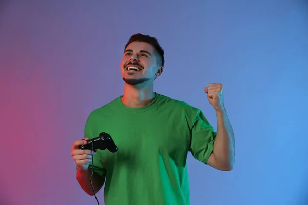 Glücklicher Junger Mann Nach Gewonnenem Videospiel Auf Farbigem Hintergrund — Stockfoto