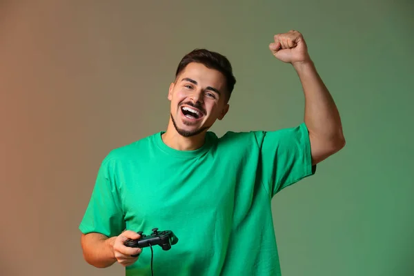Glücklicher Junger Mann Nach Gewonnenem Videospiel Auf Farbigem Hintergrund — Stockfoto