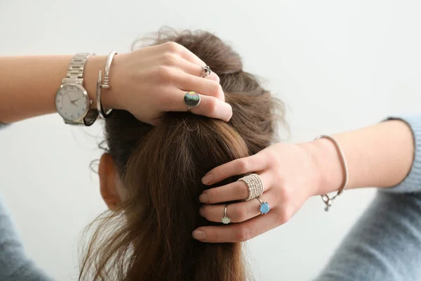 Beautiful Young Woman Stylish Bijouterie Doing Her Hair White Background — Zdjęcie stockowe