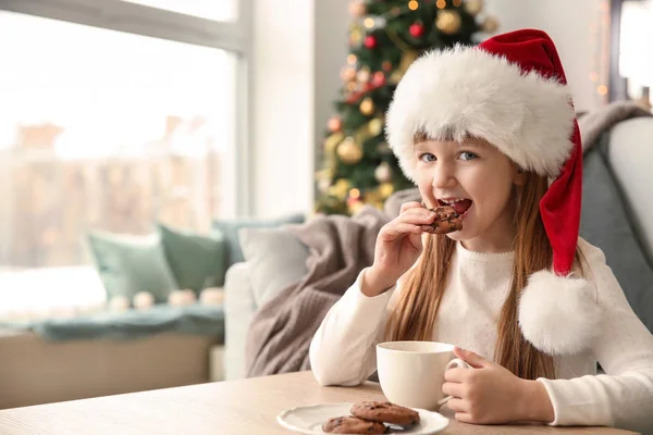 Menina Bonito Chapéu Santa Beber Chocolate Quente Comer Biscoitos Casa — Fotografia de Stock