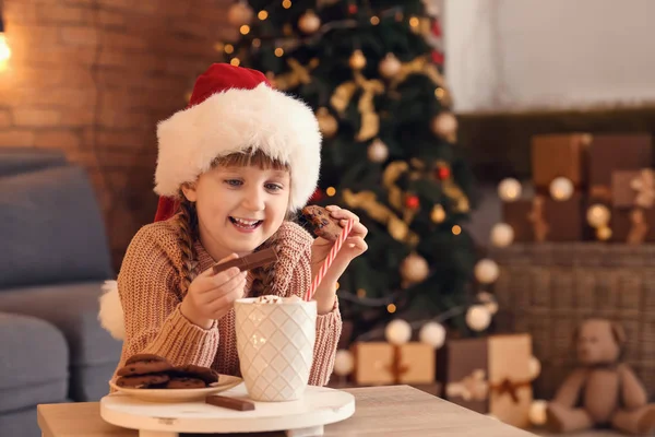 Ładna Dziewczynka Santa Hat Gorąca Czekolada Picia Jedzenia Ciasteczka Domu — Zdjęcie stockowe