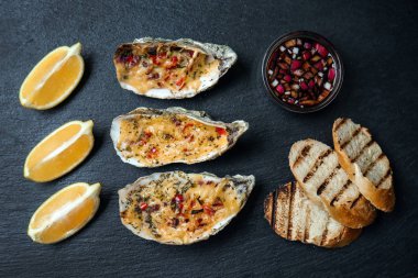 Lezzetli Fırında İstiridye limon, sos ve koyu arka plan üzerine sos ile