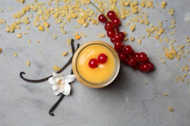 Lezzetli vanilyalı puding ve çilek gri masada kavanoz