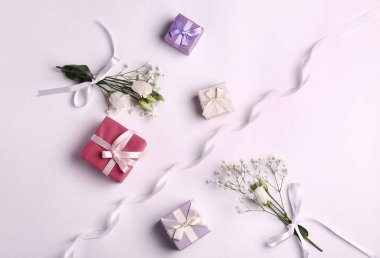 Festival hediye kutuları ve beyaz arka plan üzerinde çiçekler