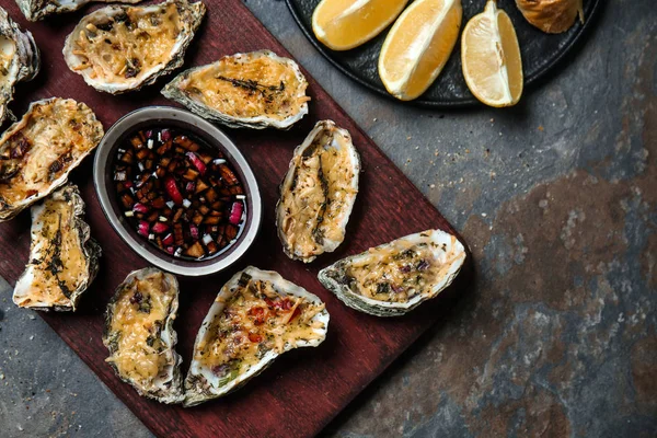 Ahşap tahta lezzetli pişmiş istiridye ve gri masada sos ile