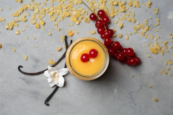 Lezzetli vanilyalı puding ve çilek gri masada kavanoz