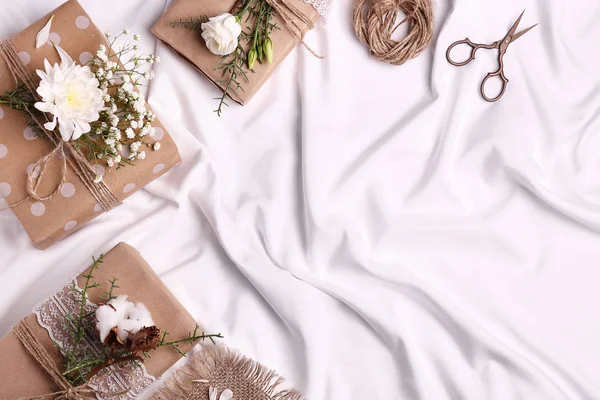 Handmade gift boxes with flowers on white cloth