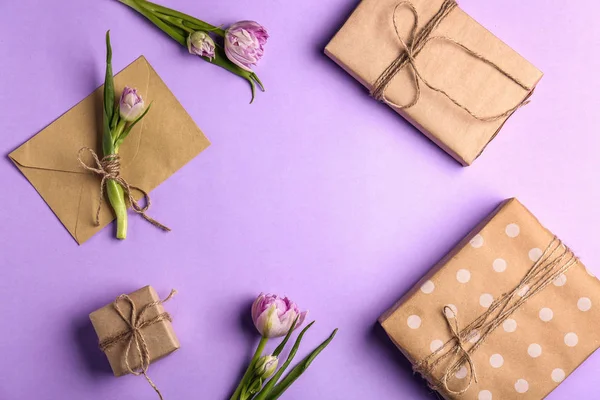 Composition with beautiful gift boxes and flowers on color background