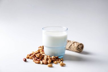 Bardak taze süt ve beyaz zemin üzerine fındık