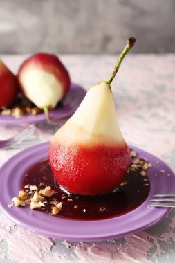 Renk tablosu üzerinde kırmızı şarap lezzetli haşlanmış armut ile plaka