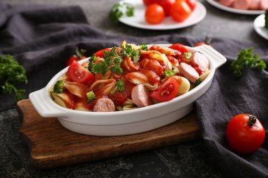 Sosis ve masada seramik tabak sos ile lezzetli makarna