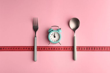 Çatal, teyp ve çalar saat renk arka plan üzerinde ölçüm ile kompozisyon. Diyet kavramı