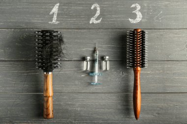 Saç fırçaları, ampul ve ahşap arka plan üzerinde şırınga ile kompozisyon