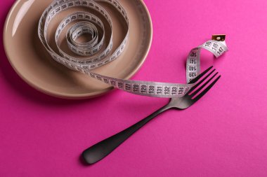 Çatal ve plaka üzerinde bant ölçme ile arka planını renklendirin. Diyet kavramı