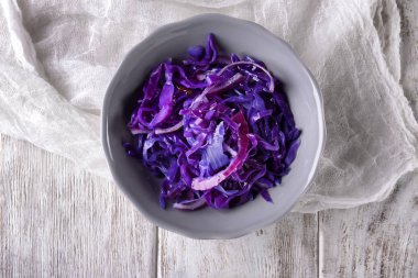 Ahşap masa üzerinde lezzetli fermente lahana ile kase