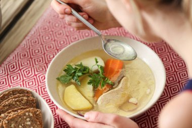 Masada lezzetli çorba içen bir kadın.
