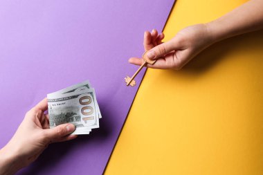 Erkek her anahtar ve para renk arka plan üzerinde veren eller. İpotek kavramı