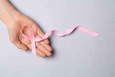 El ışık arka plan üzerinde pembe kurdele ile. Meme kanseri bilinçlendirme kavramı