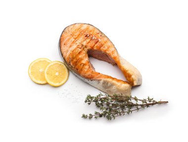 Beyaz arka planda limonlu ızgara somon bifteği.