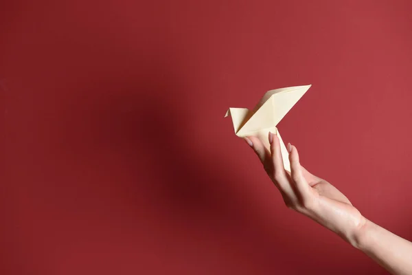 Main Féminine Avec Origami Oiseau Sur Fond Couleur — Photo