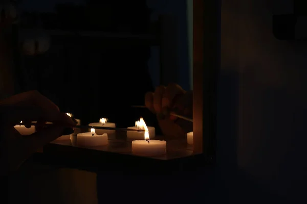 Woman Lighting Candles Shelf Dark Room — Stock Photo, Image